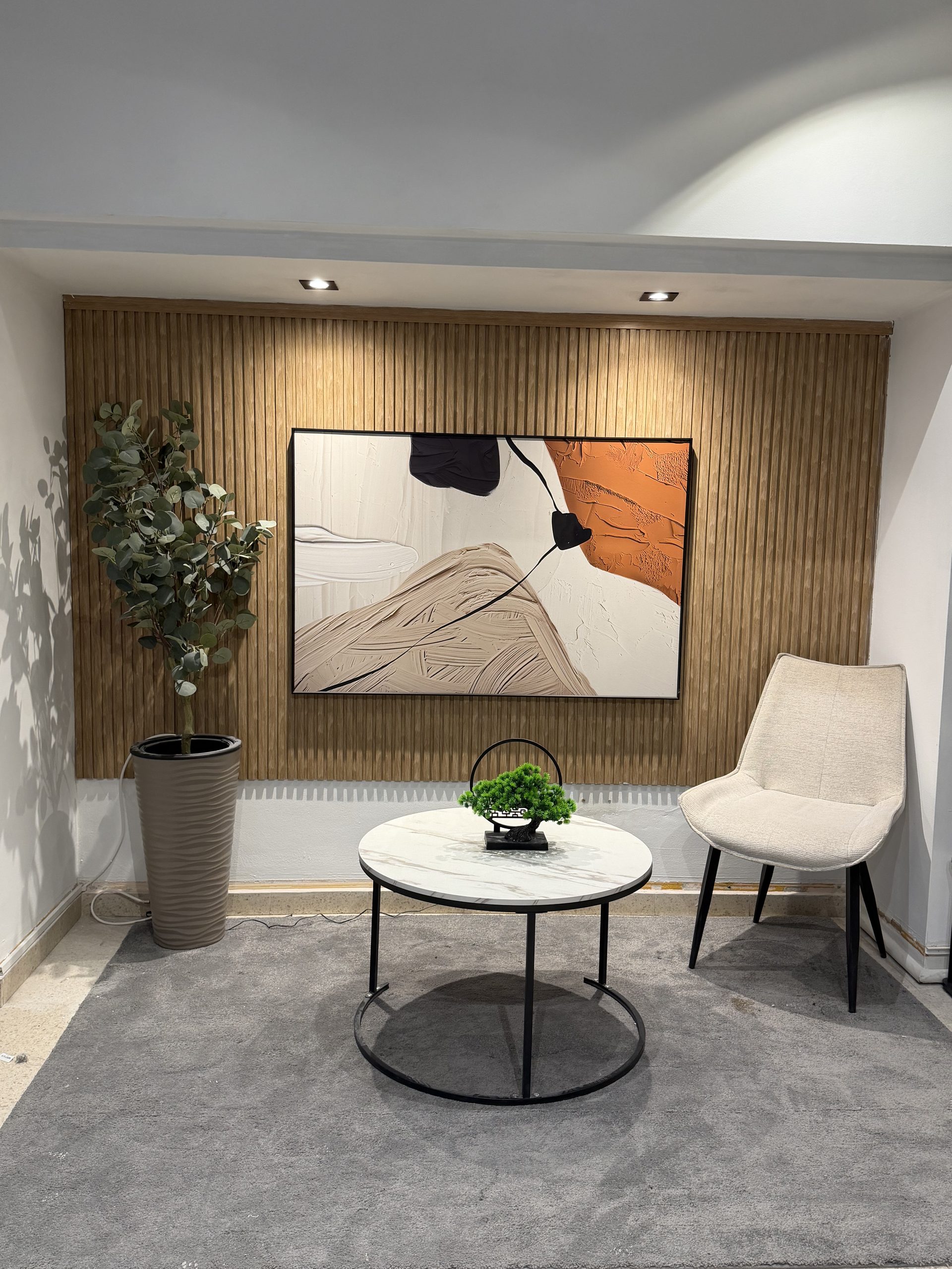 Lounge editorial con paneles de madera, obra original y mobiliario curado